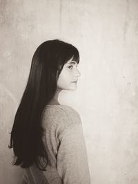 Portrait of woman standing against wall.side view of a girl i  monochrome tone.