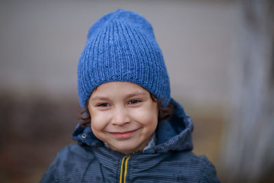 Close-up of smiling boy looking away during winter