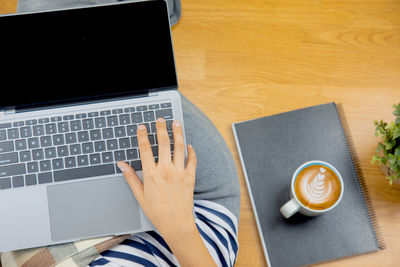 Low section of person using laptop on table