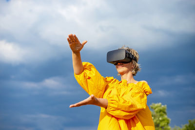 Low angle view of woman standing against sky