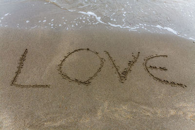 High angle view of text on sand at beach