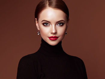 Portrait of young woman against pink background