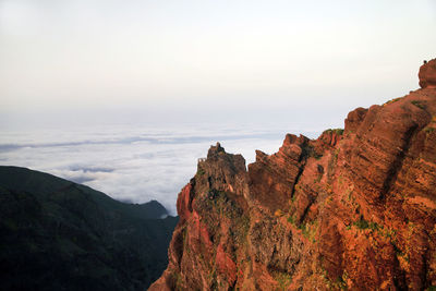 High section of cliff against cloudy sky