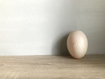 Close-up of apple on table against white wall