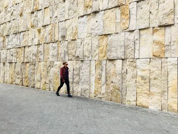 Rear view of woman walking on footpath