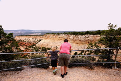 Rear view of woman with son looking at mountains from observation point