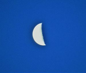 Low angle view of moon against blue sky