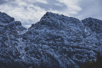 Low angle view of snowcapped mountains against sky