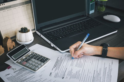 Midsection of man using laptop on table
