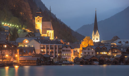 Illuminated buildings in city at dusk