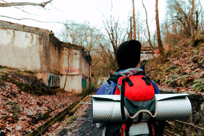 Unrecognizable backpacker trekking in autumn forest