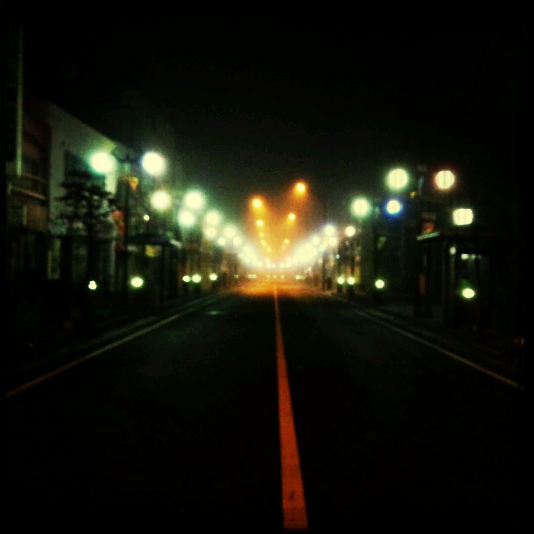 illuminated, night, the way forward, building exterior, street light, transportation, architecture, city, diminishing perspective, built structure, road, lighting equipment, street, vanishing point, road marking, city life, empty, light - natural phenomenon, outdoors, sky