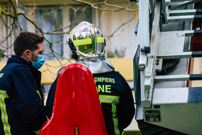 Rear view of men working on bus