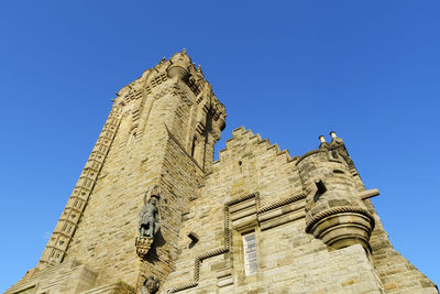 Low angle view of historical building against clear blue sky