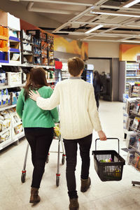 Rear view of couple walking in supermarket