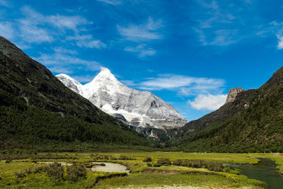 Scenic view of mountains against cloudy sky