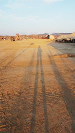 Shadow of people on land against sky