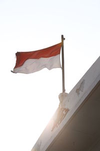 Low angle view of flags against clear sky