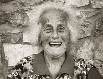 Portrait of smiling woman against wall