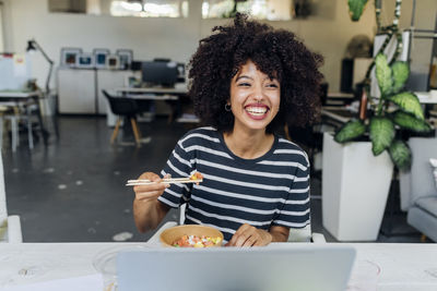 Happy businesswoman having poke bowl in lunch at office