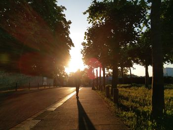 Person walking on footpath at sunset