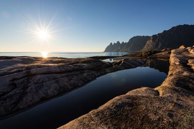 Midnight sun over cliffs of tungeneset on senja in northern norway at a warm calm summer night