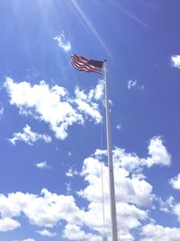 Low angle view of american flag against sky on sunny day