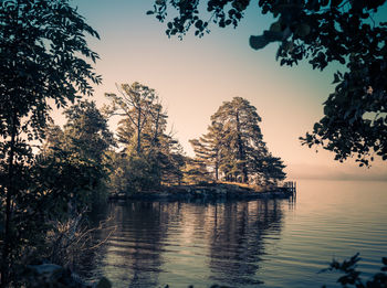 Scenic view of lake against clear sky at sunset