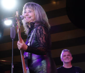 Close-up of happy woman standing against illuminated lights