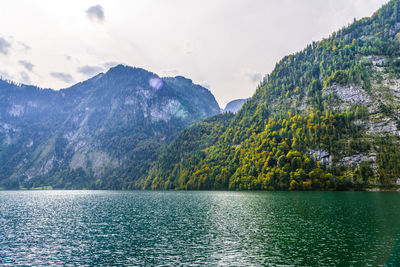 Scenic view of lake by mountains against sky