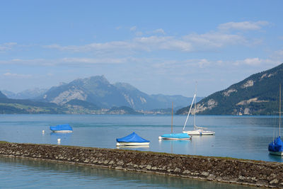 Sailboats on sea against mountains