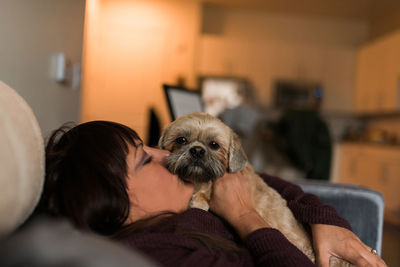 Midsection of woman with dog at home