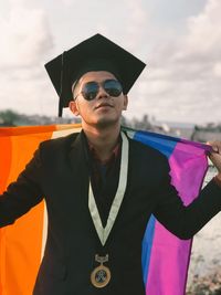 Man wearing sunglasses standing against sky