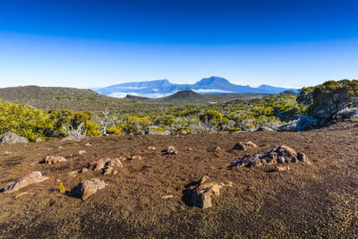 Scenic view of mountains against blue sky