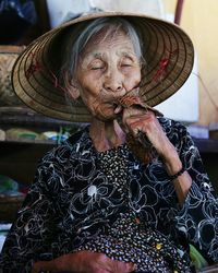 Close-up of senior woman with eyes closed wearing hat