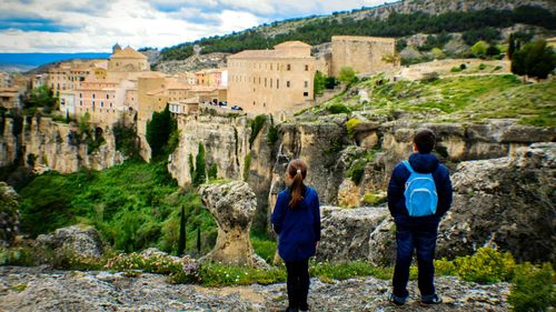 Rear view of two people overlooking built structures