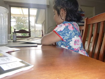 Girl sitting on table at home