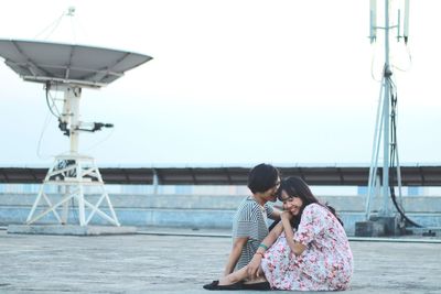 Young couple on boat against clear sky