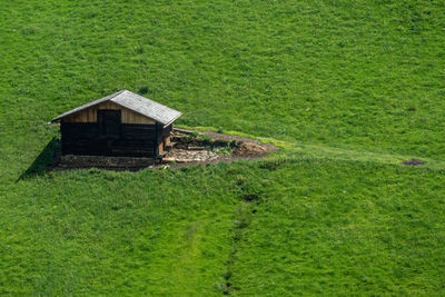 House on field by green grass