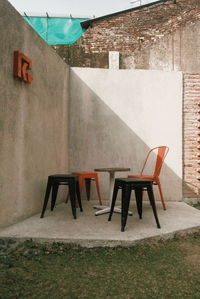 Empty chairs and tables against wall in building