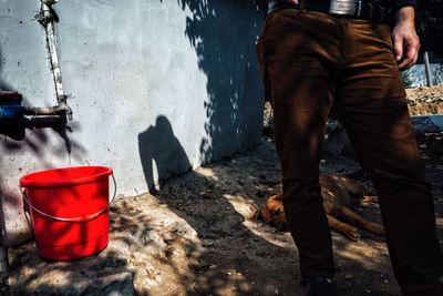 Low section of man standing by water