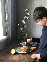 Side view of boy preparing pancake at home