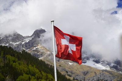 Red flag on snowcapped mountain against sky