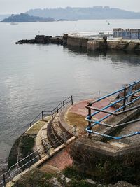 High angle view of steps by sea against sky