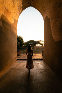 Rear view of woman walking in corridor