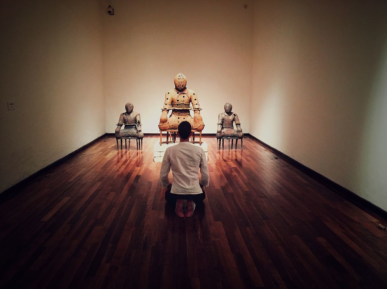 REAR VIEW OF PEOPLE SITTING ON WOODEN FLOOR