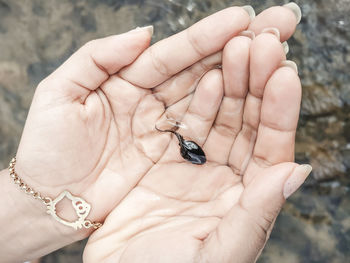 Cropped image of hand holding a tadpole 