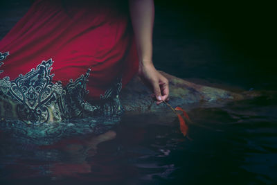 Midsection of woman with fish in sea