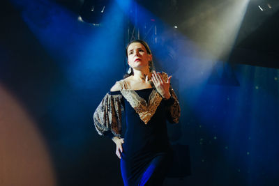 Portrait of young woman standing at night