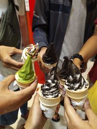 Midsection of people holding ice cream